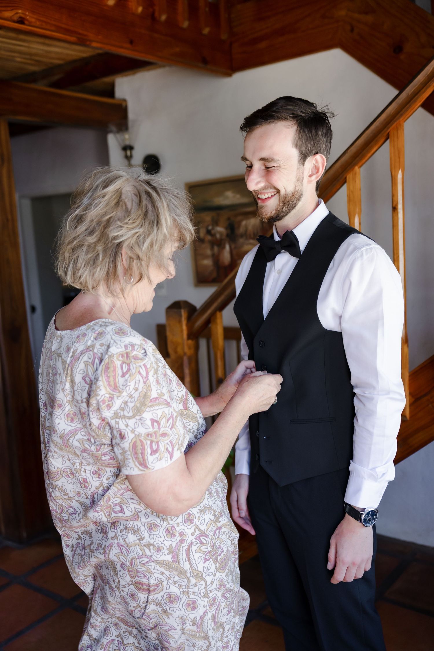 Two people in formal attire sharing a tender moment in a rustic indoor setting.