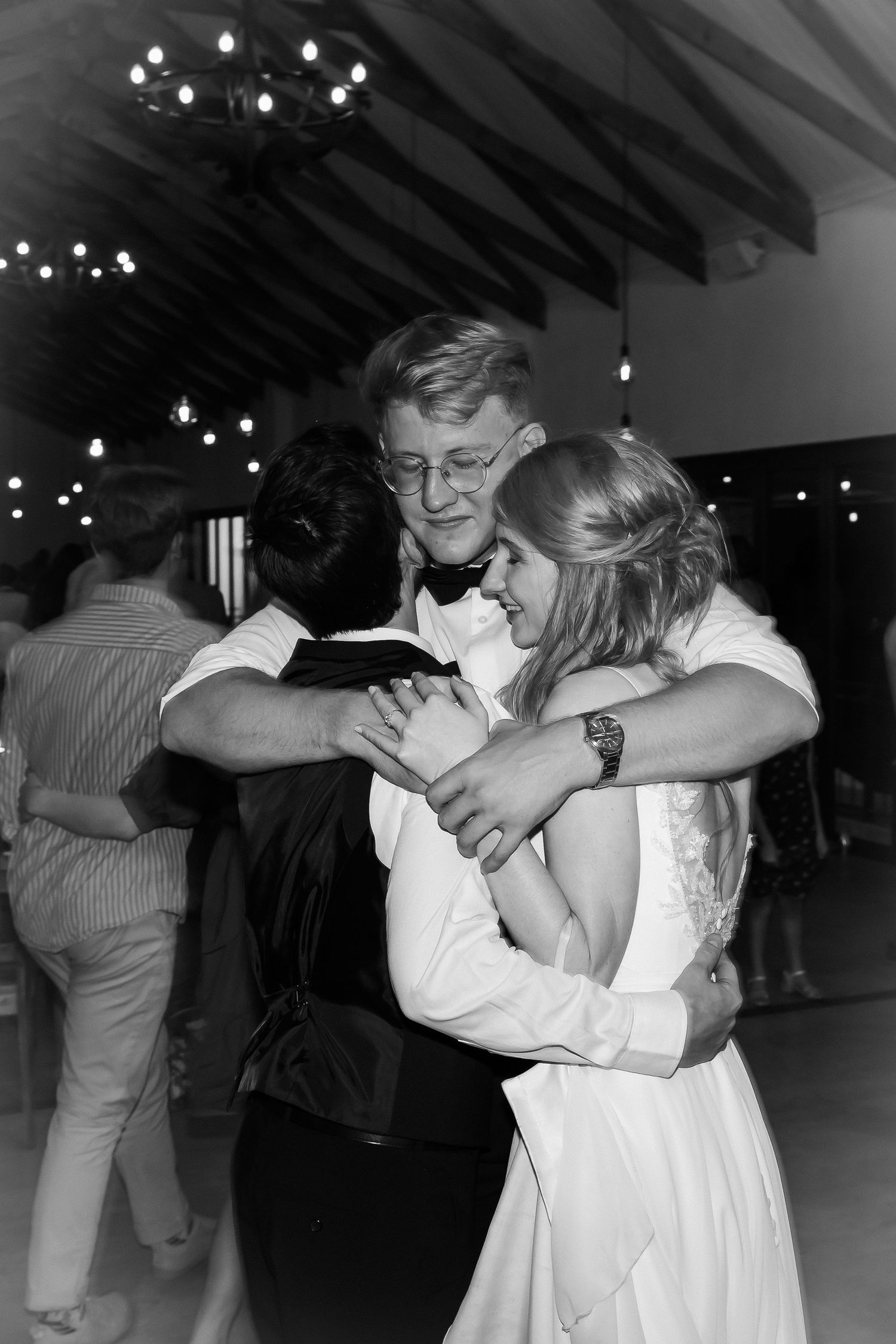 Emotional dance moment captured in black and white under twinkling reception lights.