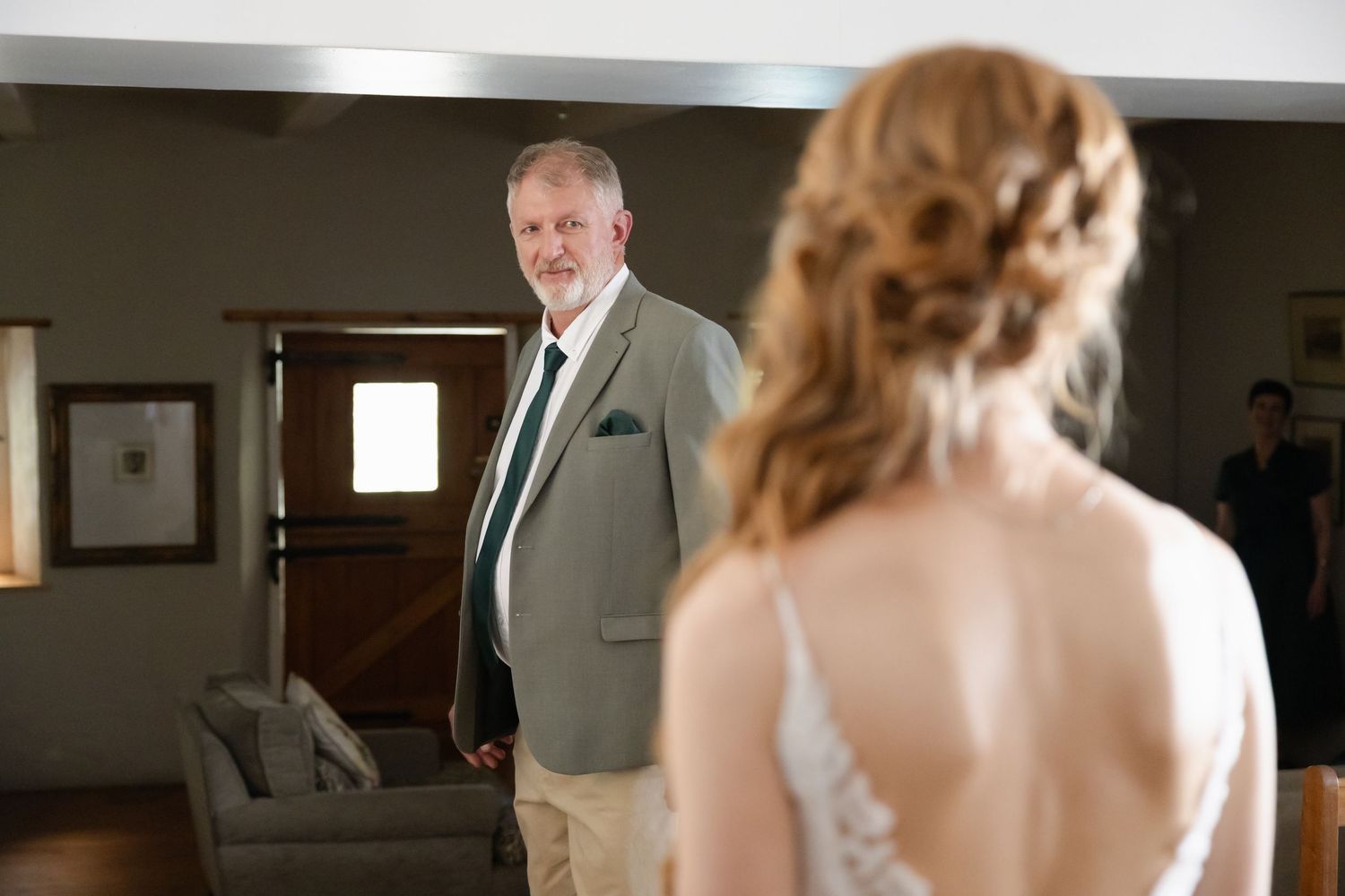 An emotional first look moment between father and bride in an indoor venue setting.