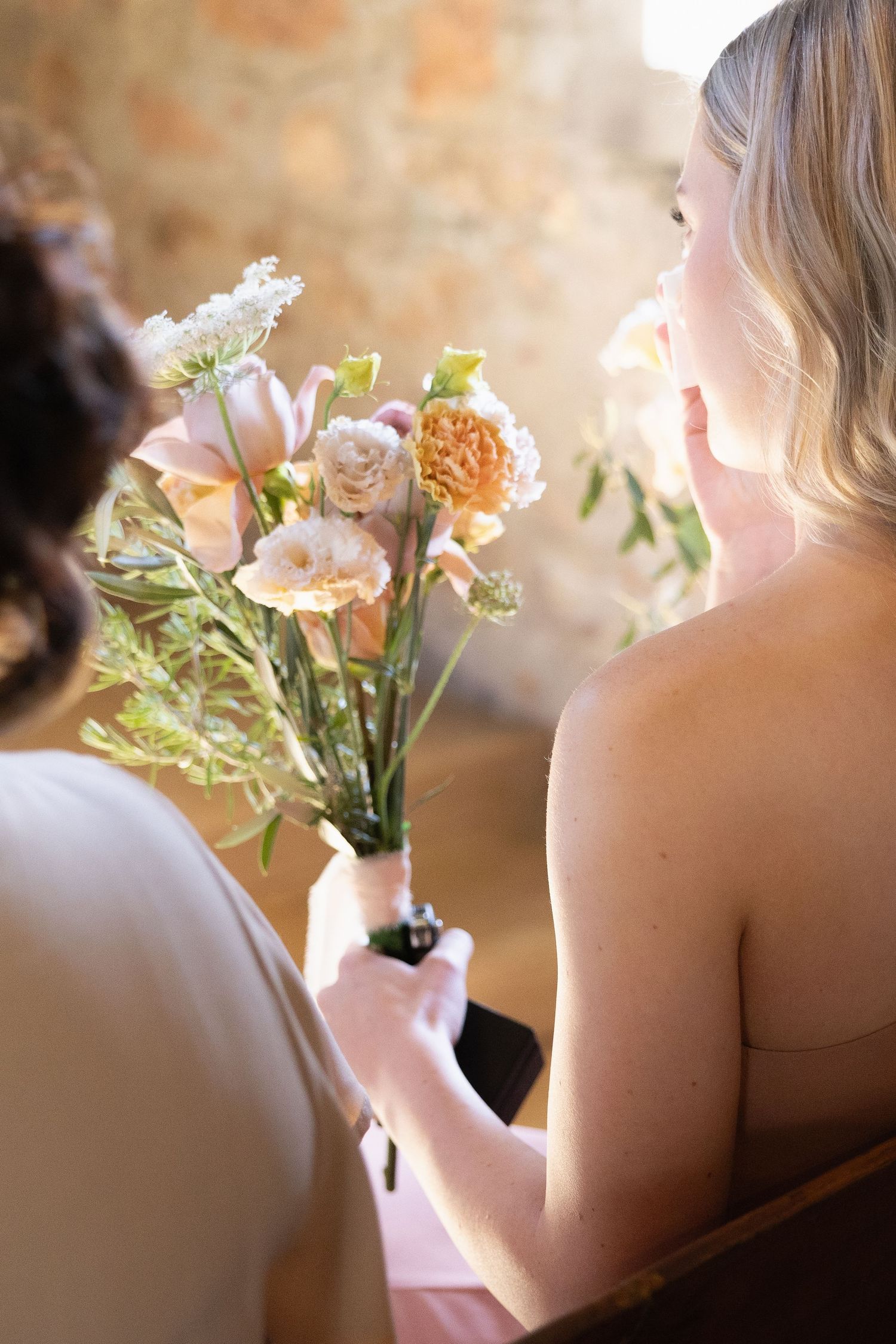 Close-up shots of someone holding delicate floral arrangements with peach and white blooms.