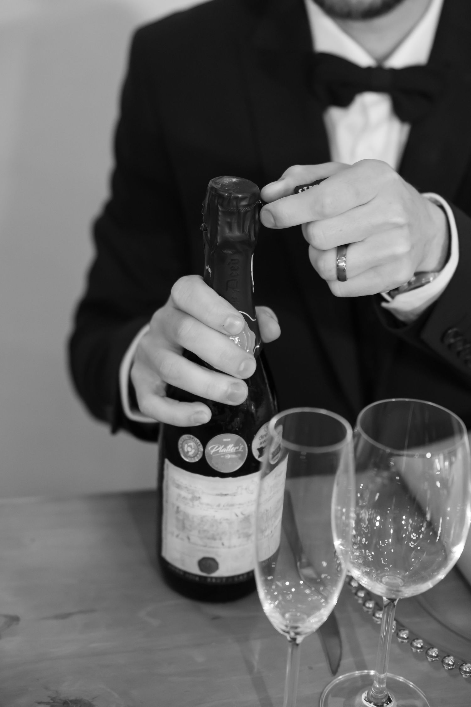 Pouring champagne into elegant glasses at a formal event.