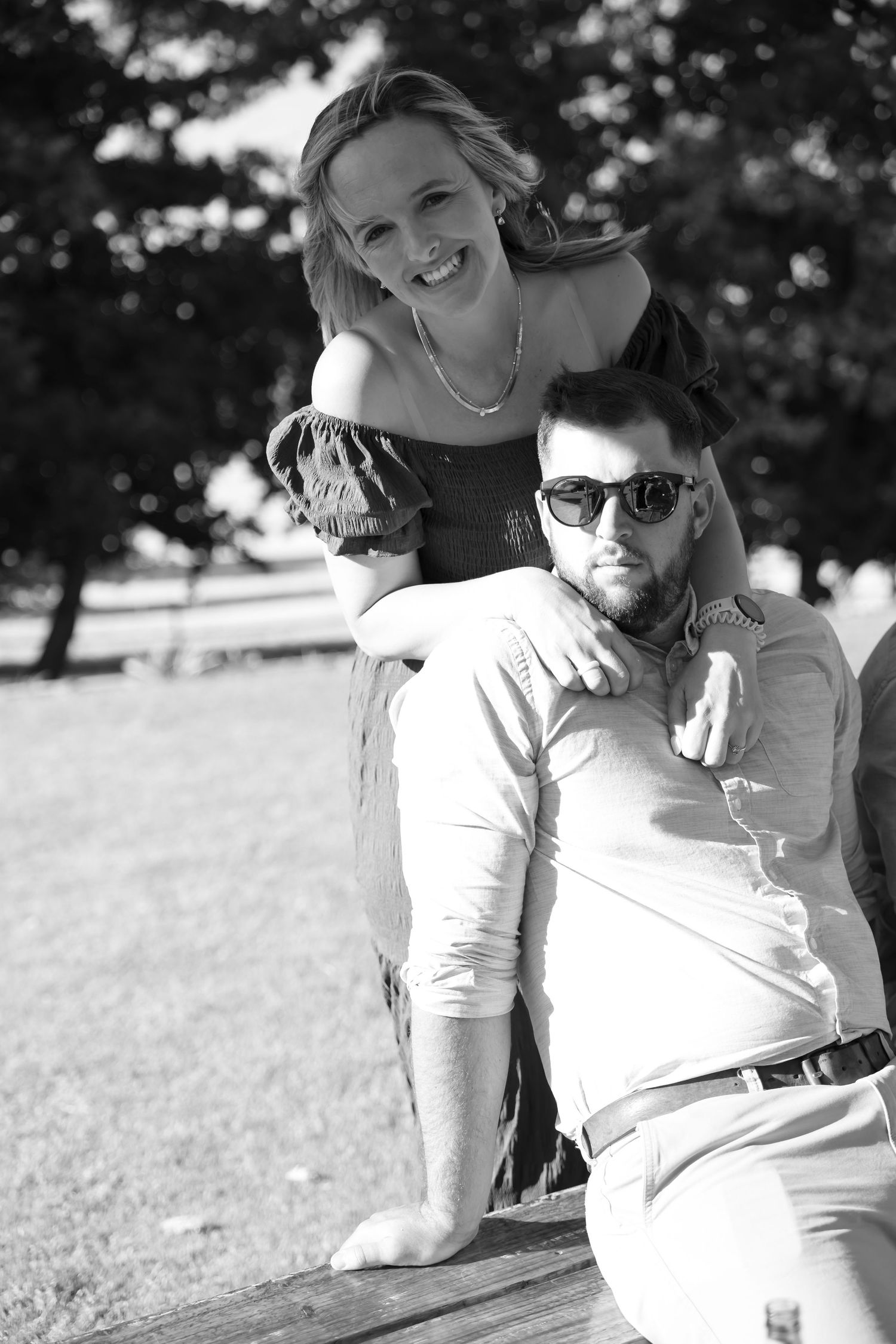 Black and white photo series showing a couple lying in grass sharing intimate moments together outdoors.