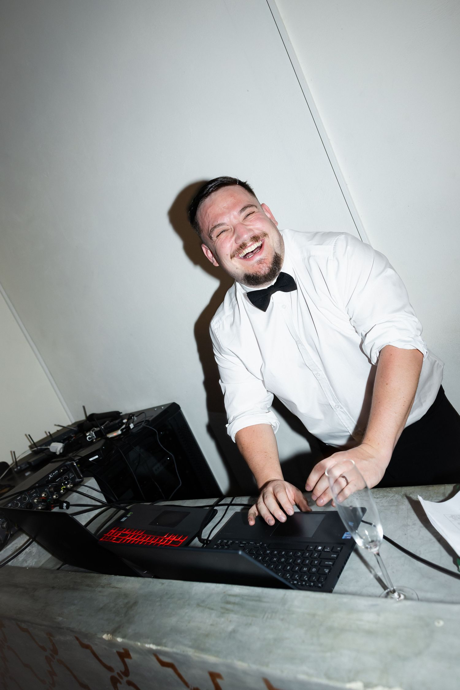 A person in white shirt lies on floor with computer keyboard and equipment, showing joyful expressions in multiple poses.