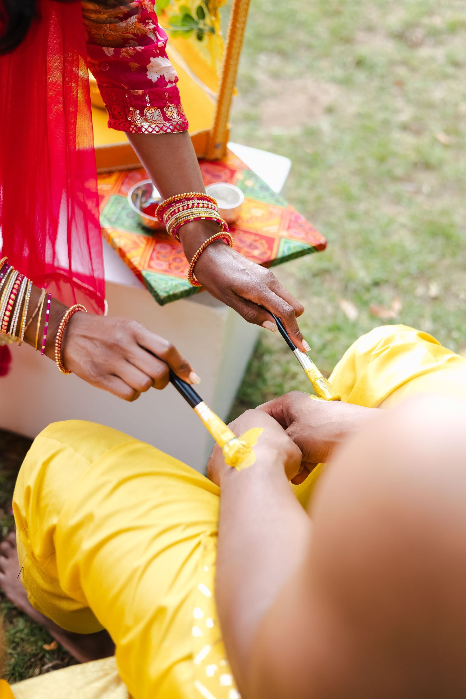 Close-up sequence showing hands applying turmeric paste during a traditional haldi ceremony.