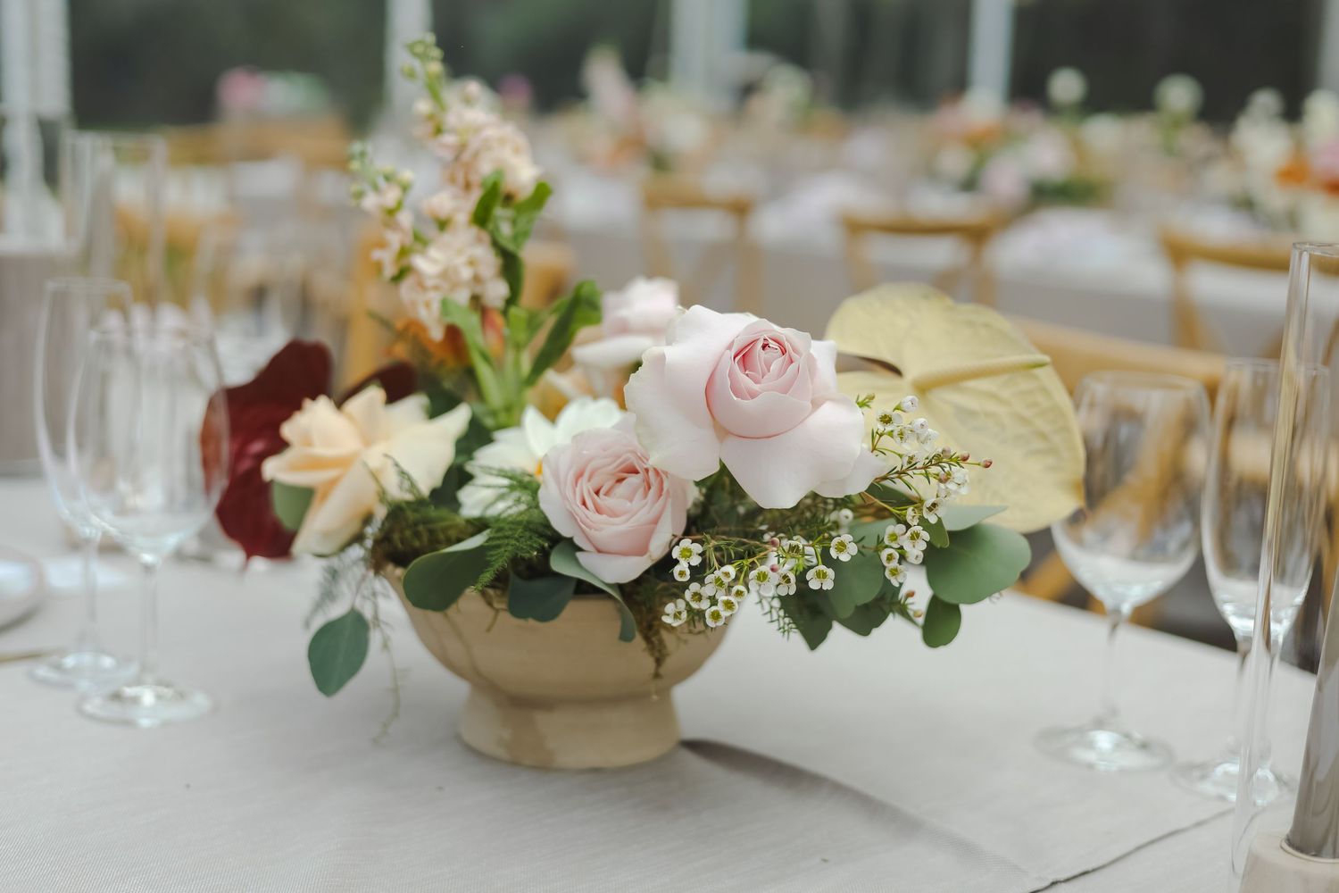 Elegant table settings with delicate floral centerpieces and crystal glassware at a wedding reception.