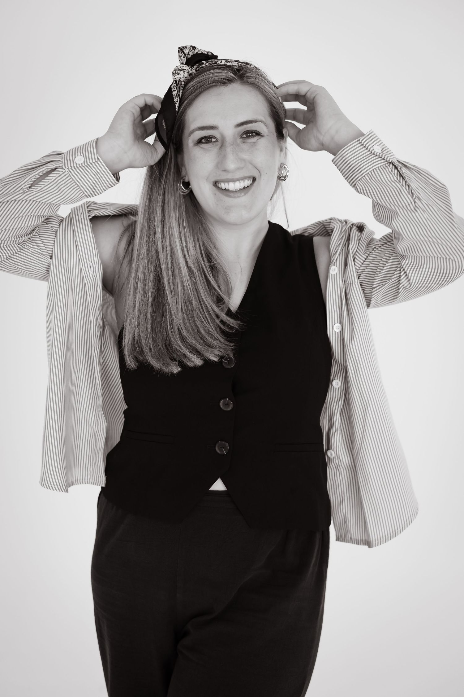A series of black and white portraits showing a person in a black vest and striped sleeves posing playfully against a light background.