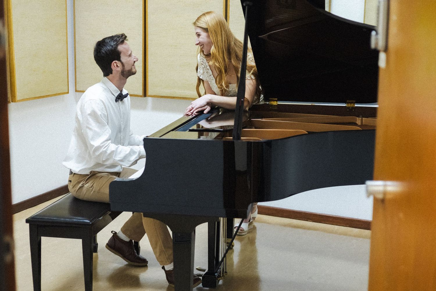 A pianist performs at a grand piano in a bright studio setting.