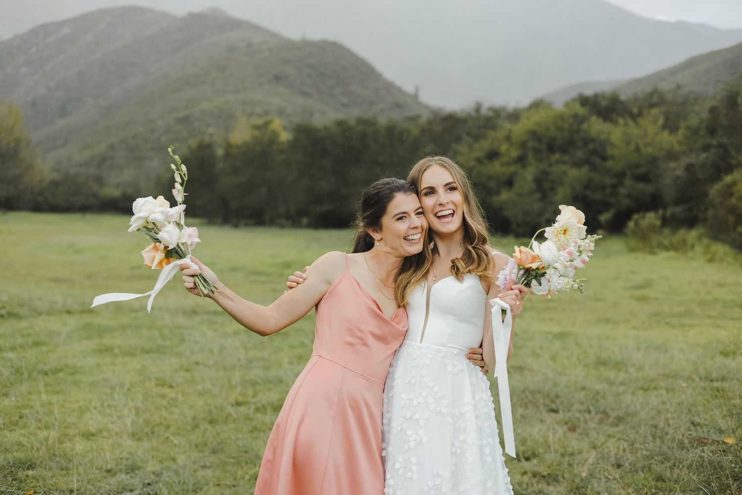 Wedding party enjoying candid moments in a scenic mountain meadow.