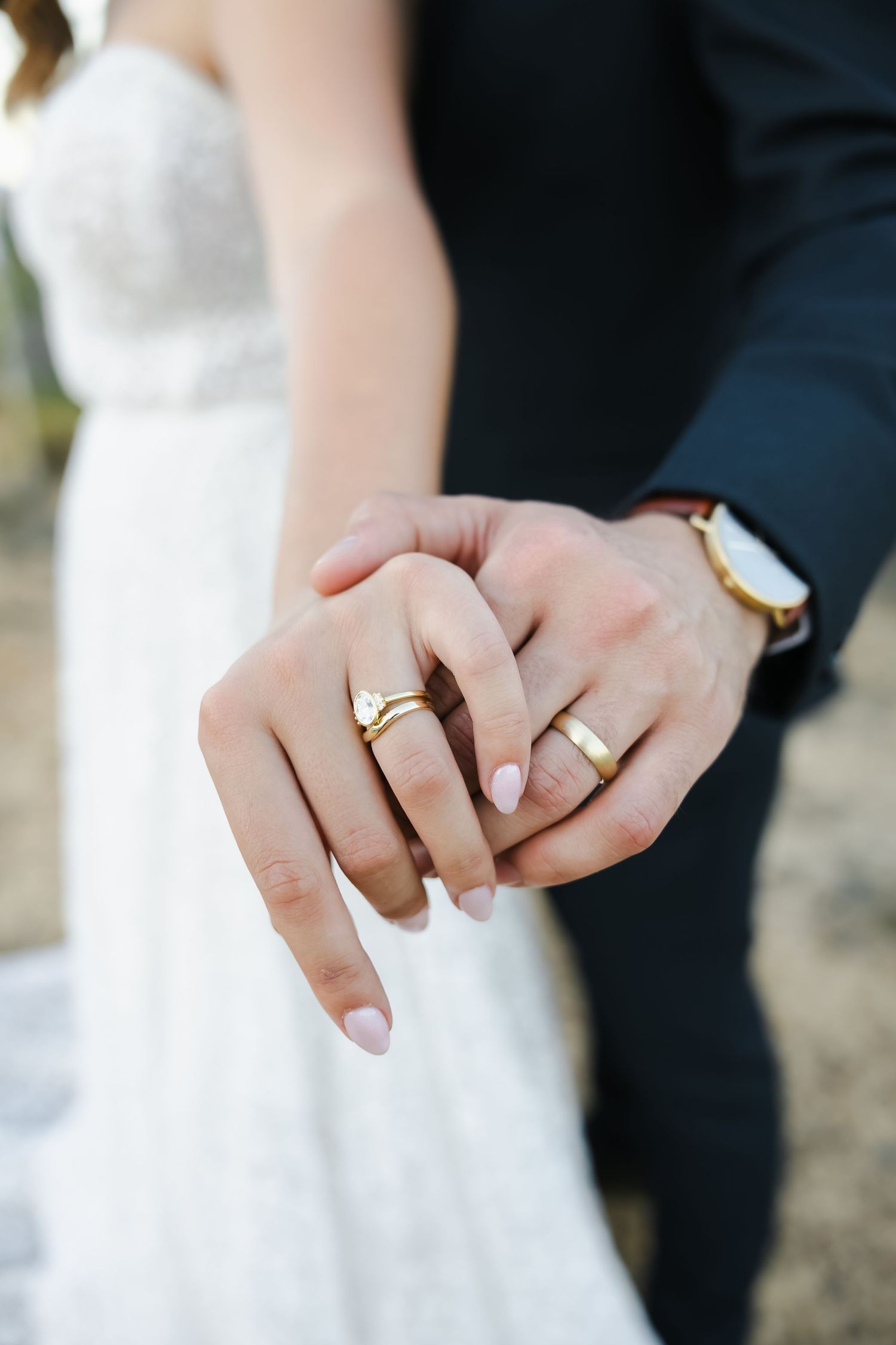 Close-up sequence of hands displaying wedding rings against a black and white background.
