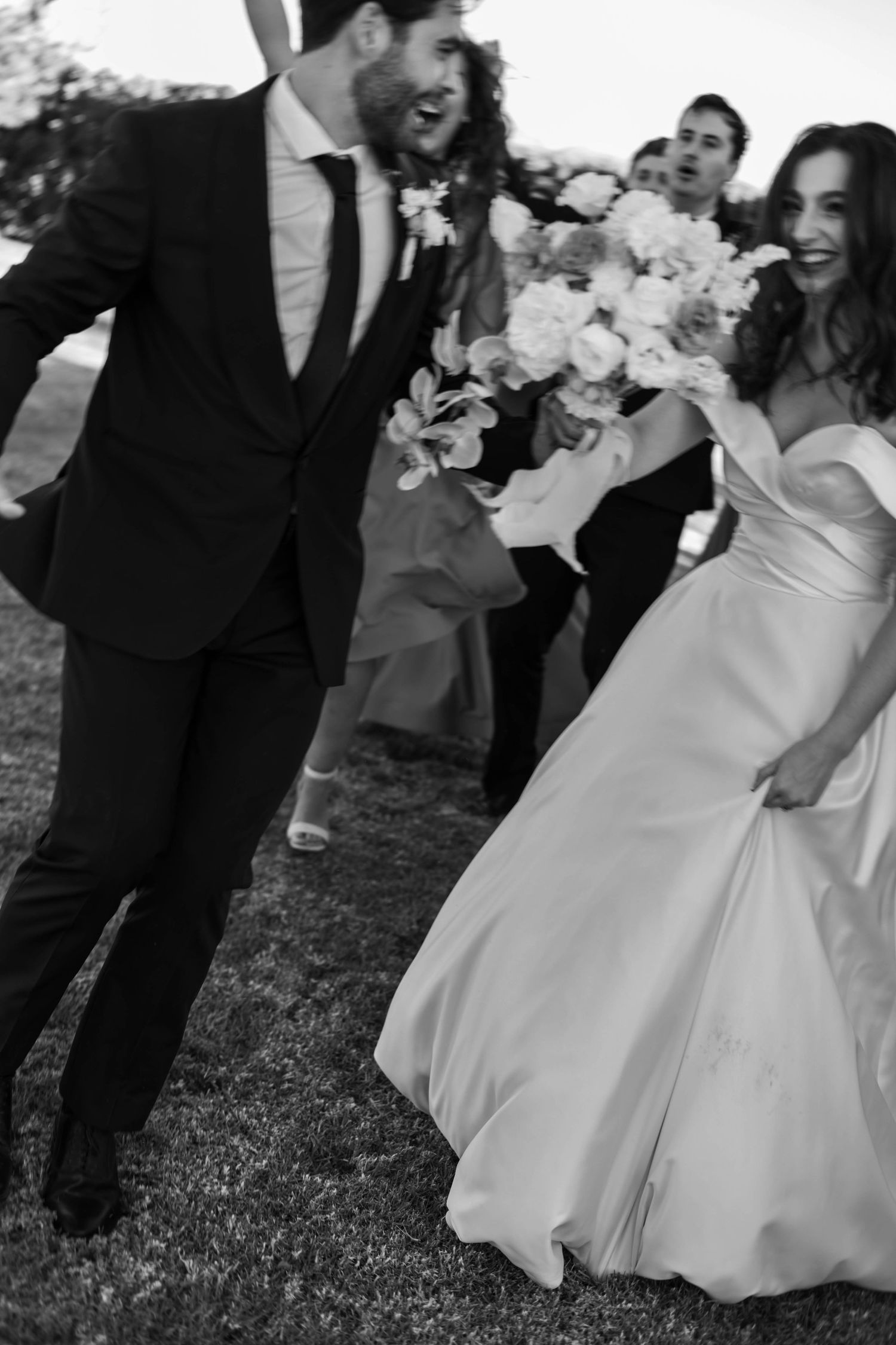Black and white wedding photos showing joyful moments between couples and wedding party members.