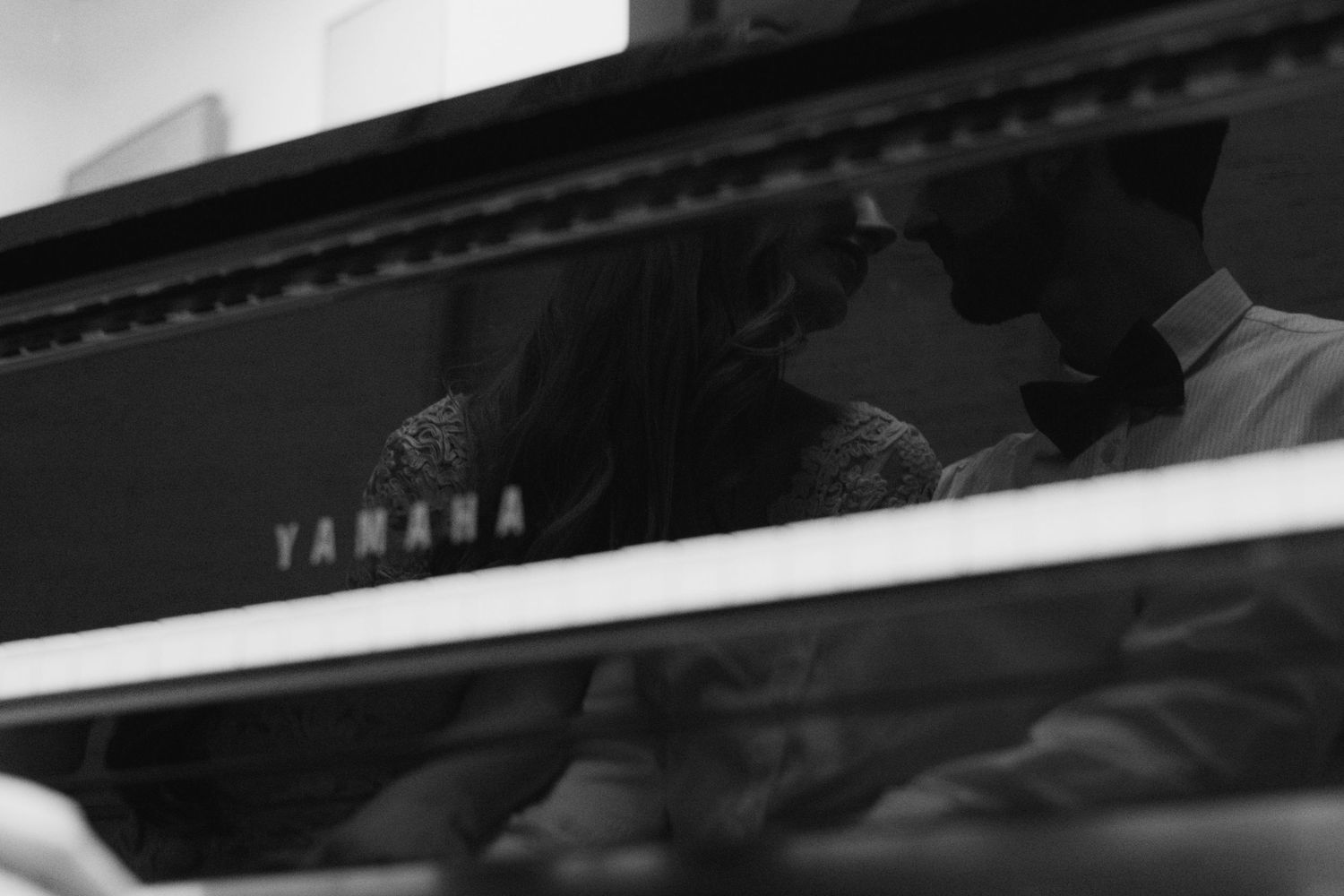 Black and white close-up shot of a Yamaha piano keyboard with partial logo visible.