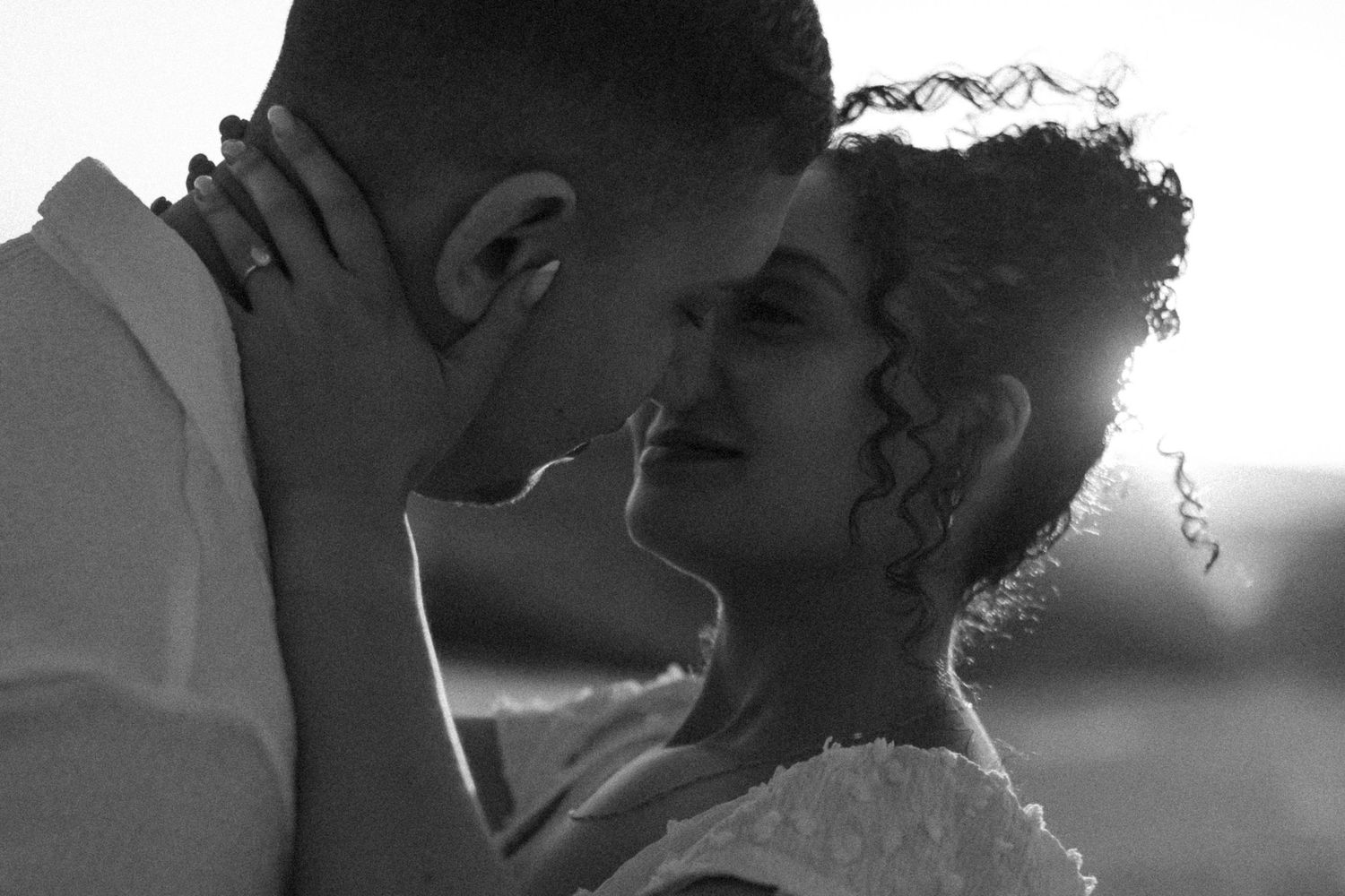 A black and white collage of five photos showing a couple sharing intimate romantic moments together.