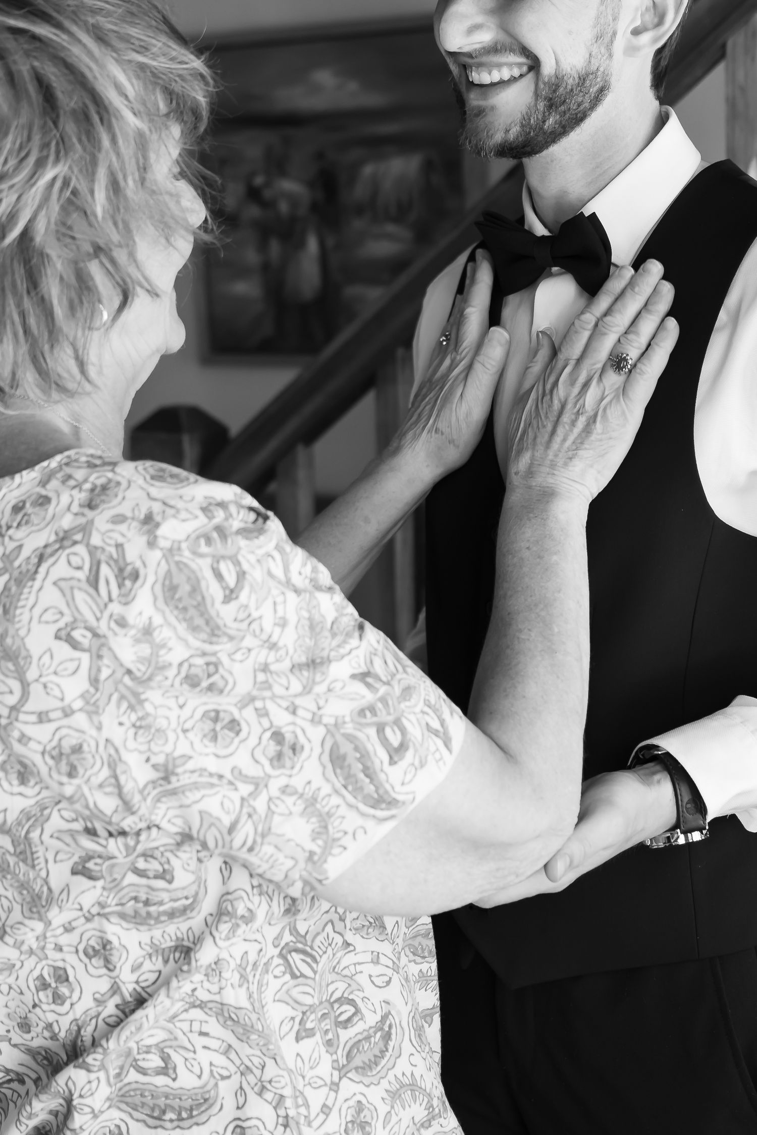 Black and white photo of two people in formal wear sharing an intimate moment.