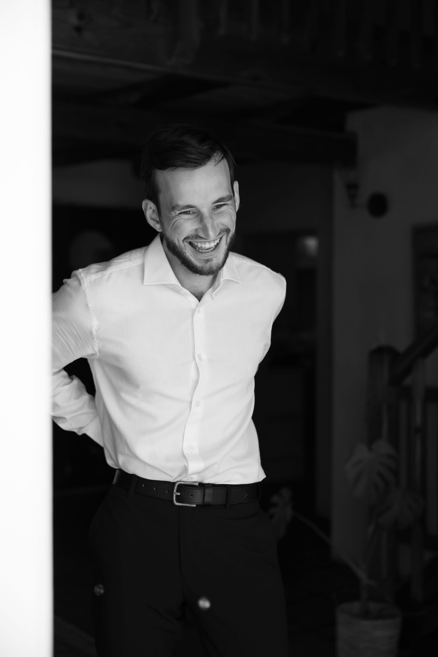 A series of black and white candid photographs showing someone in a white button-down shirt smiling and laughing.