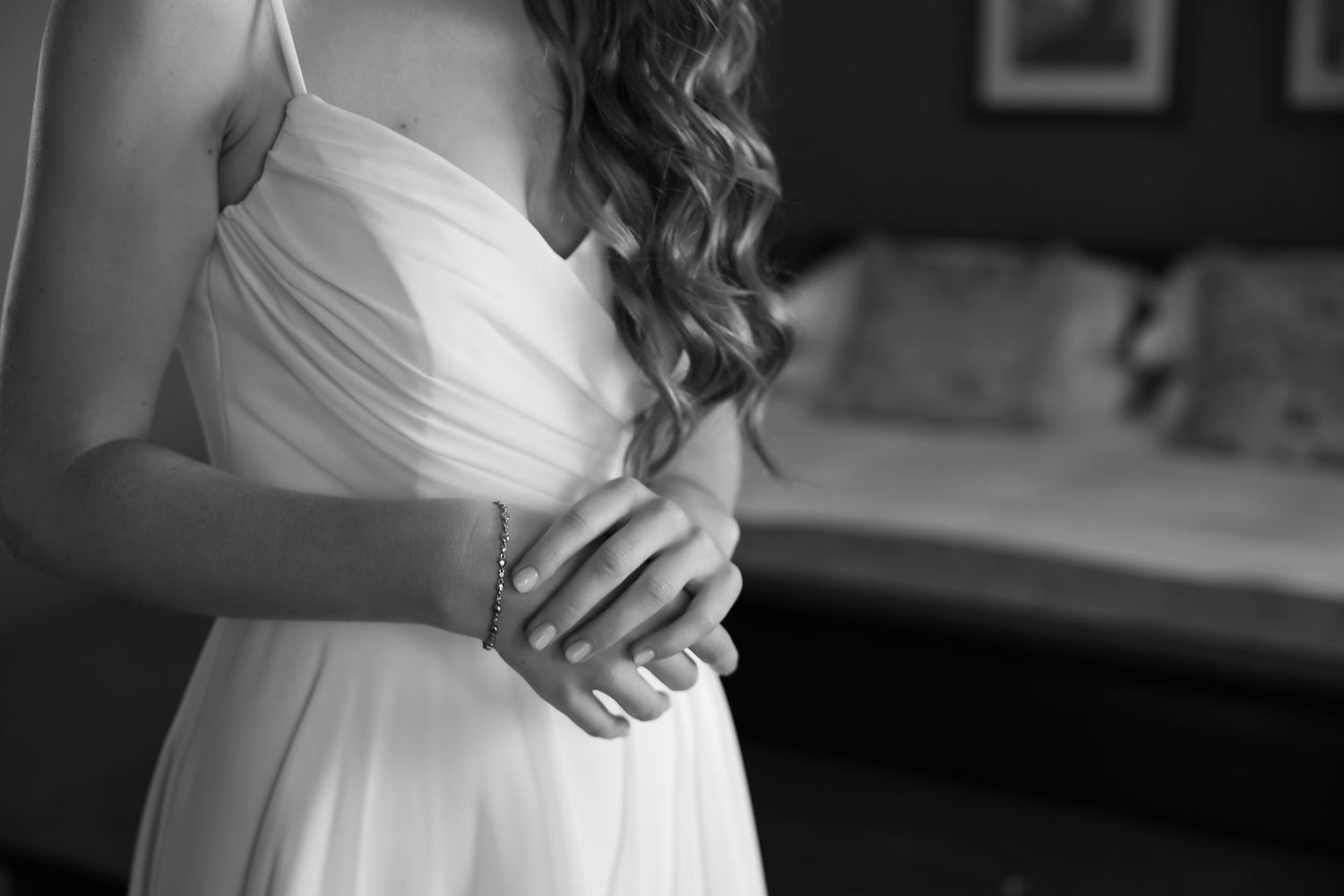 Black and white photograph capturing an emotional wedding preparation moment.