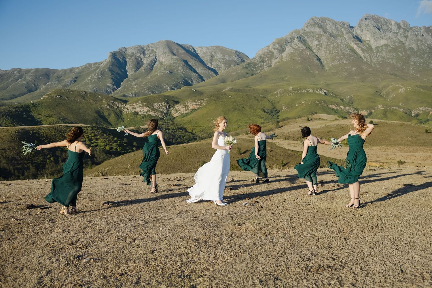 People perform yoga poses in sequence against a backdrop of majestic mountain scenery.