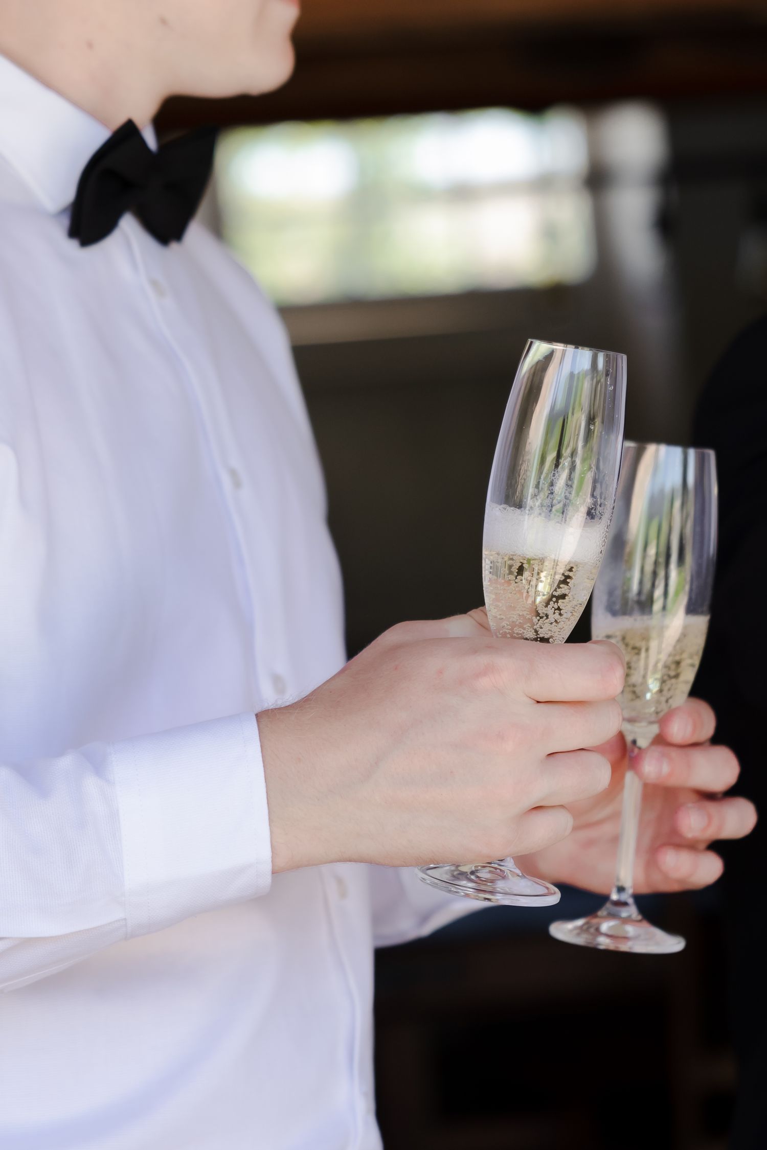 Hands holding champagne glasses in a celebratory toast.