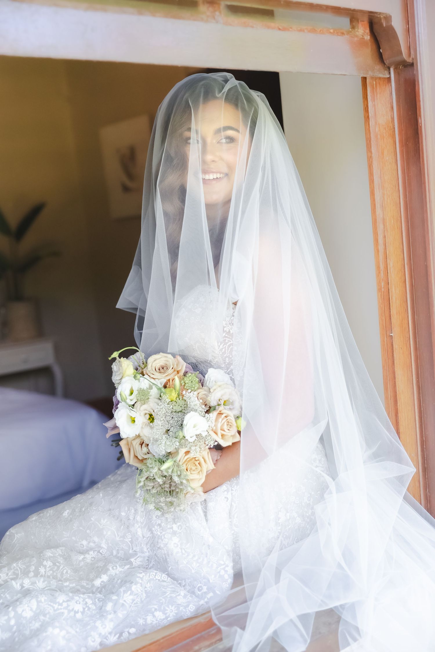 A bride in a white wedding dress and veil is captured in a series of soft, romantic mirror reflections.