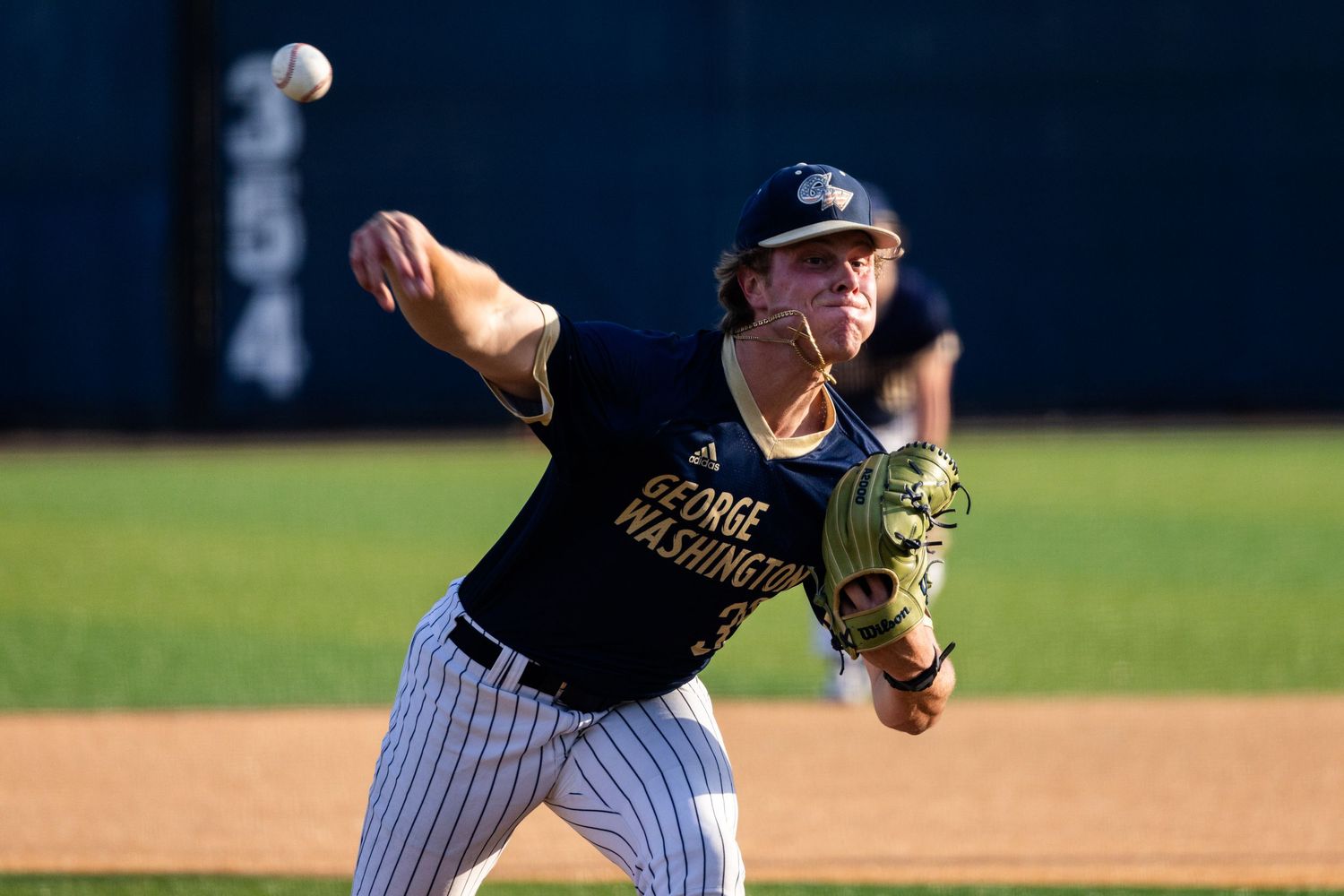 GW Baseball player throws the opening pitch.