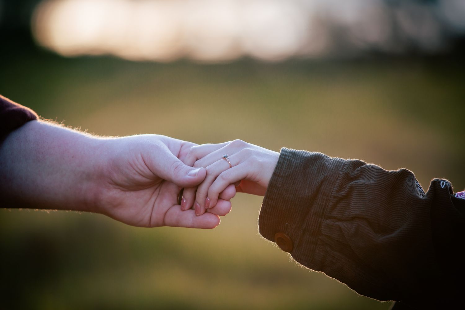 a couple look lovingly at each other at their pre wedding photoshoot. The bride-to-be shows off her ring