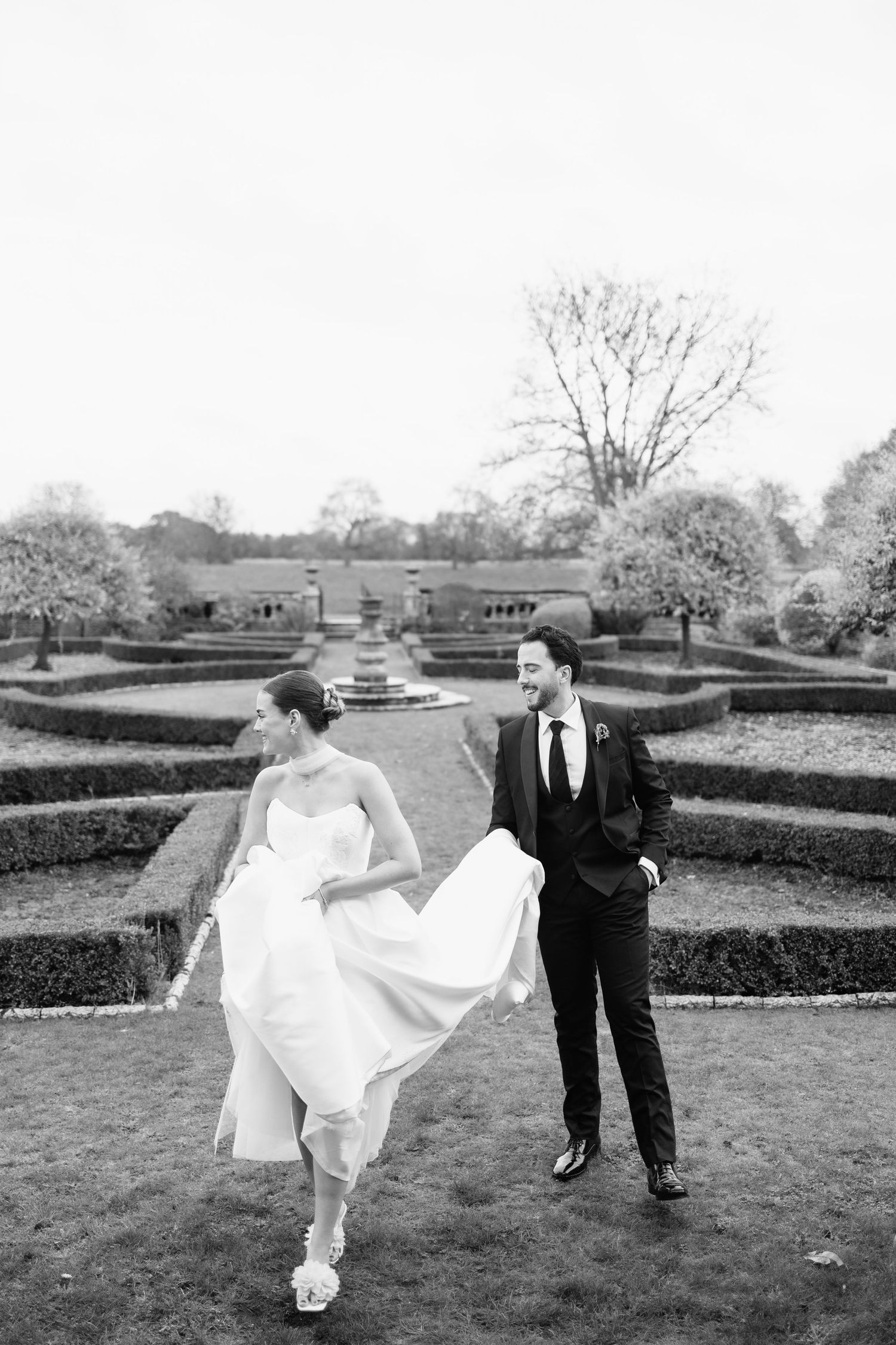 Elegant couple walking through the gardens at Berwick House in Shrewsbury