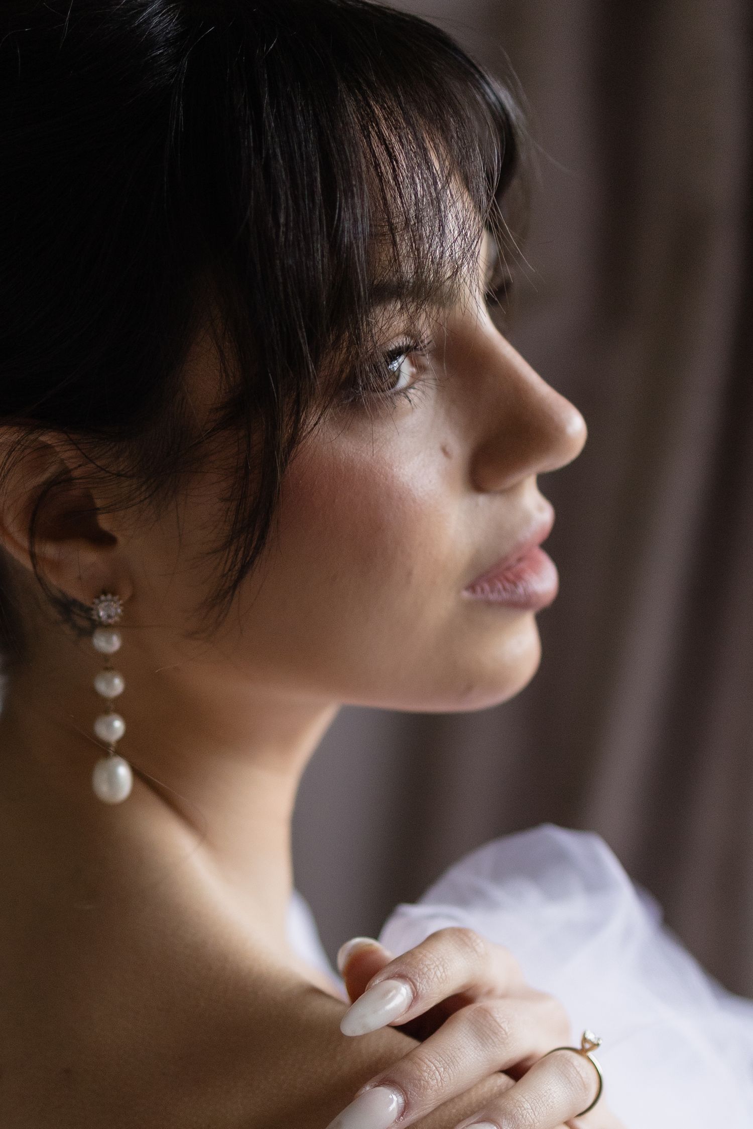 Bride puts on her earrings and final touches at Soughton Hall before the ceremony, in the rosebud room