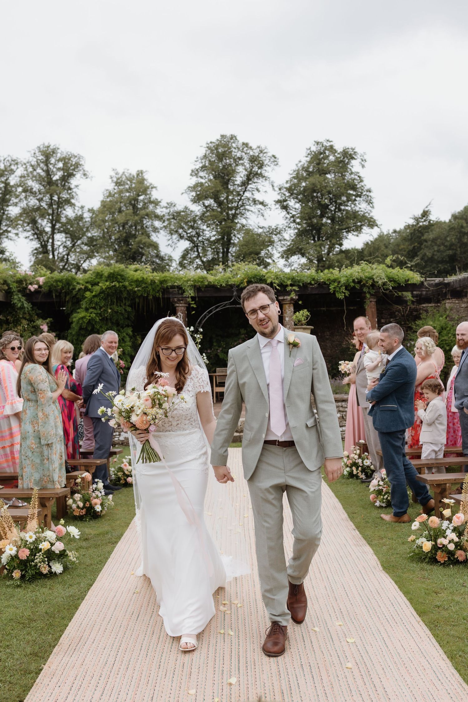 Couple framed by the old stone archway at Holesfoot estate