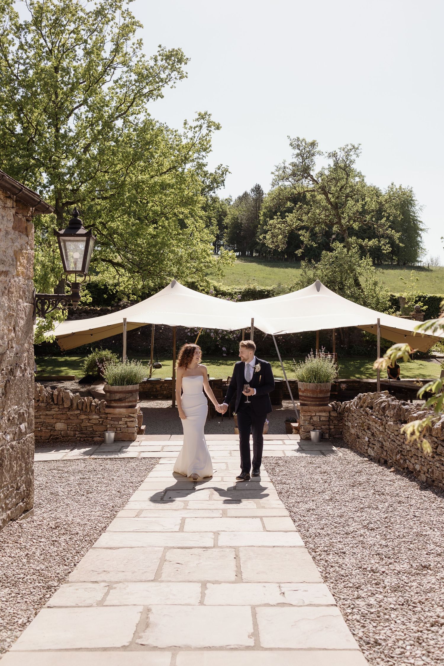 Couple walking hand in hand through the gardens at Holesfoot wedding venue