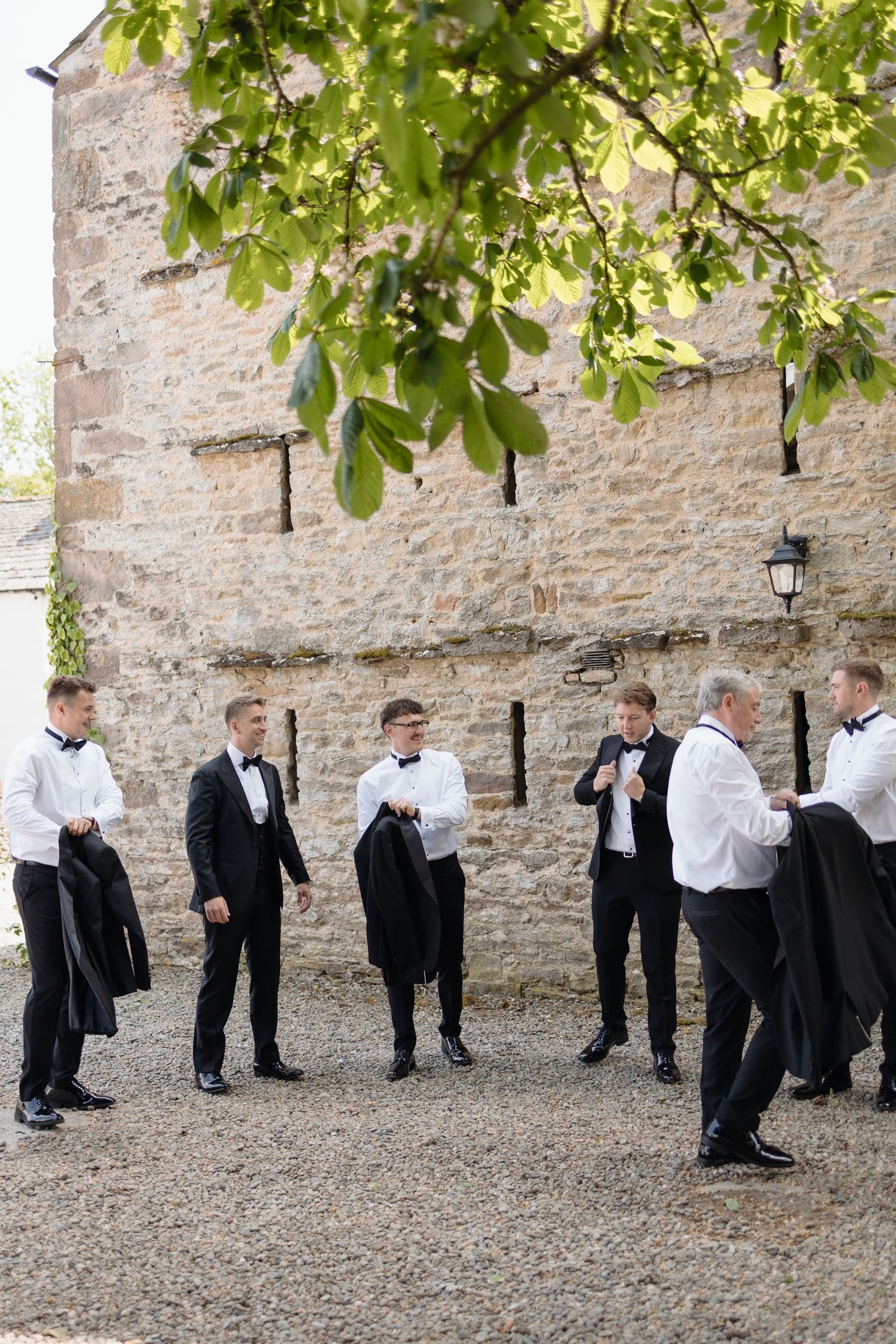 Groom and groomsmen get ready outside the barn at holesfoot