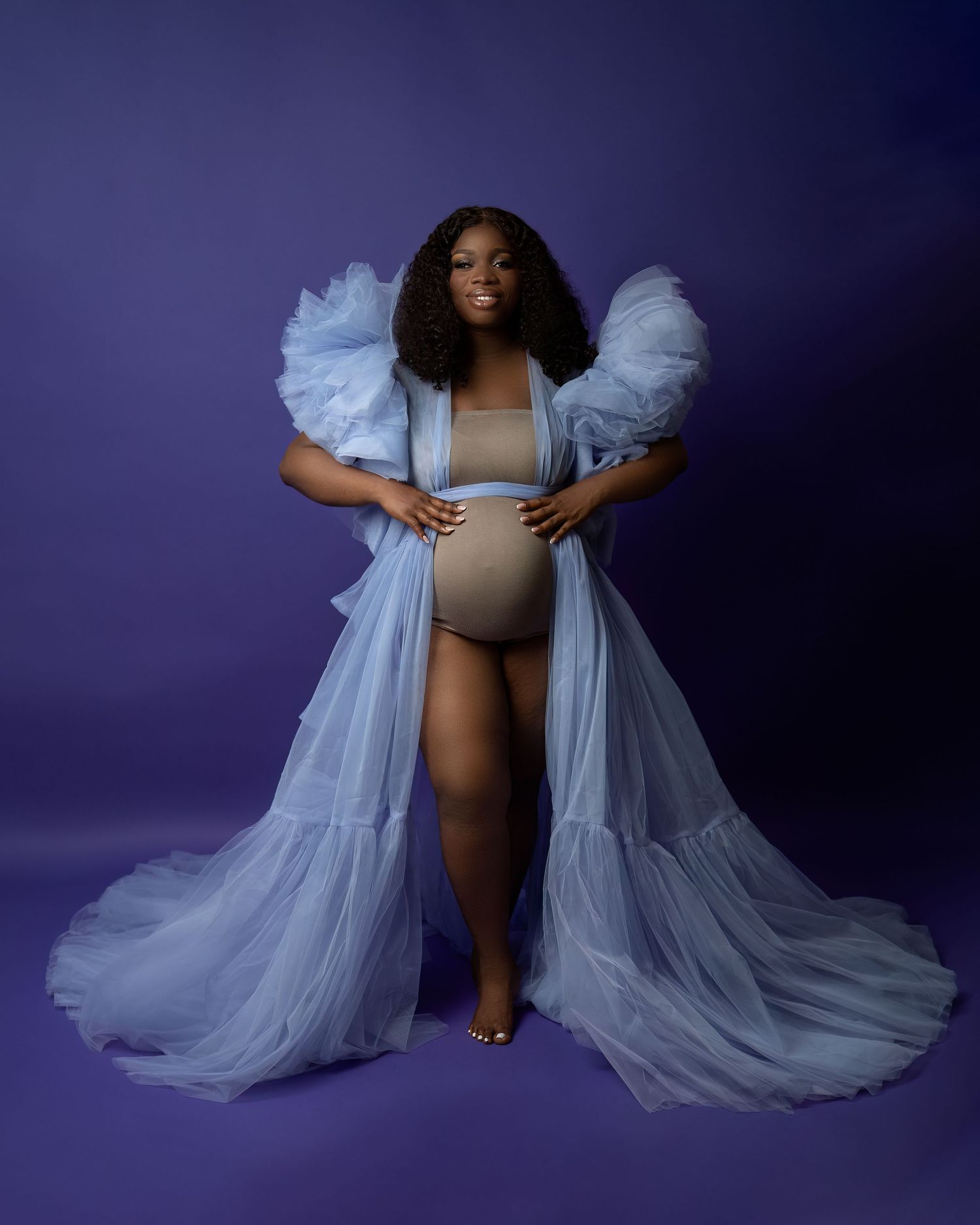 Maternity photoshoot in Gravesend Kent with pregnant woman in blue gown on purple background
