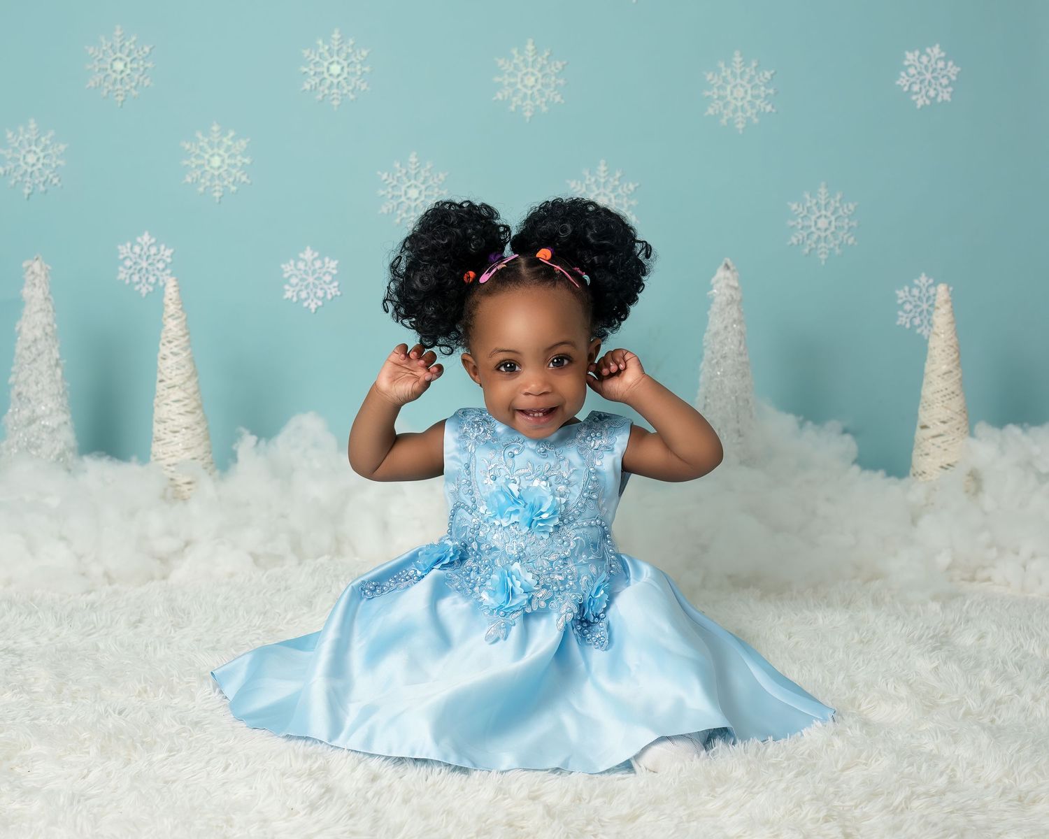 Children photography photoshoot in Gravesend Kent with girl in blue dress sitting on winter themed background