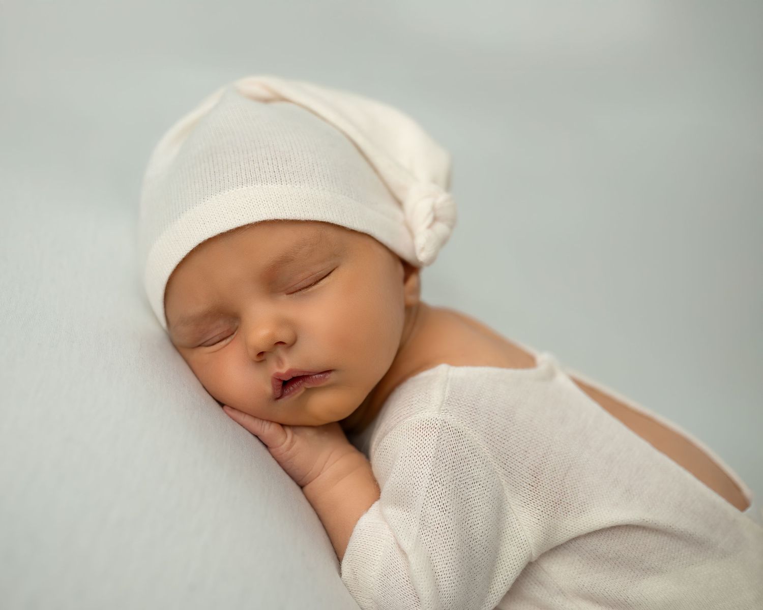 Newborn photoshoot in Gravesend Kent with baby sleeping in white outfit close up portrait