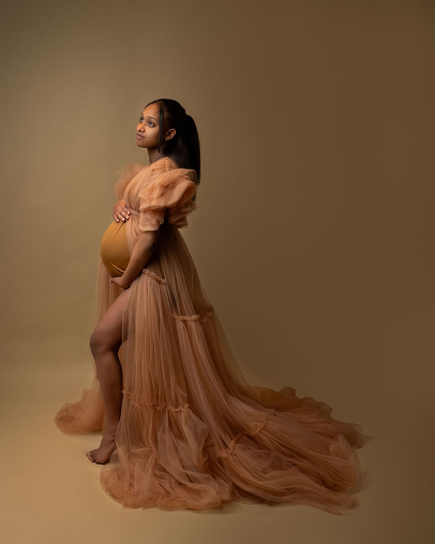 Maternity photography in Gravesend Kent with pregnant woman in flowing brown dress in studio