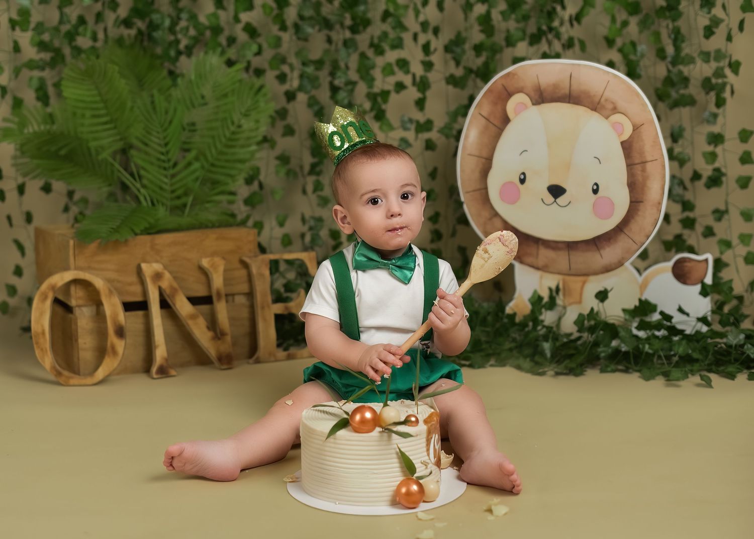 Cake smash photography session in Gravesend Kent with baby sitting in jungle themed first birthday setup