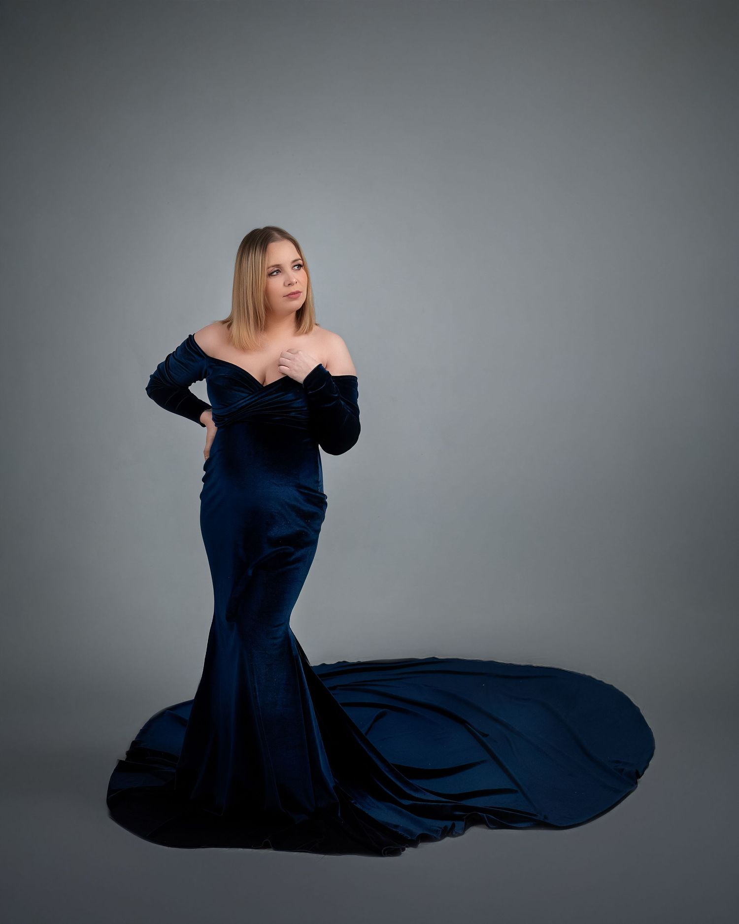 Maternity photoshoot in Gravesend Kent with pregnant woman in elegant dark blue gown in studio