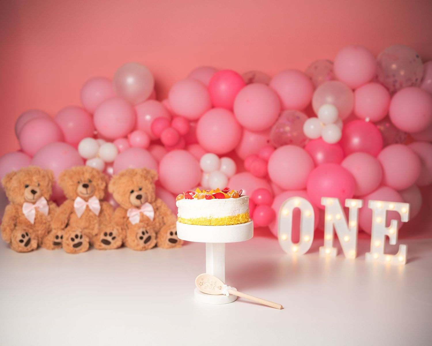 Cake smash photography in Gravesend Kent with pink balloons and birthday cake setup for first birthday