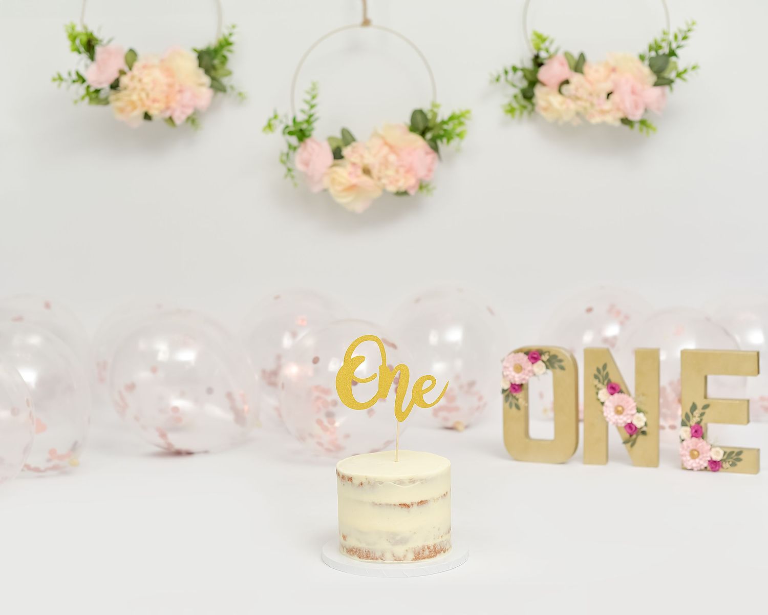 Cake smash photoshoot in Gravesend Kent with floral first birthday setup and cake display