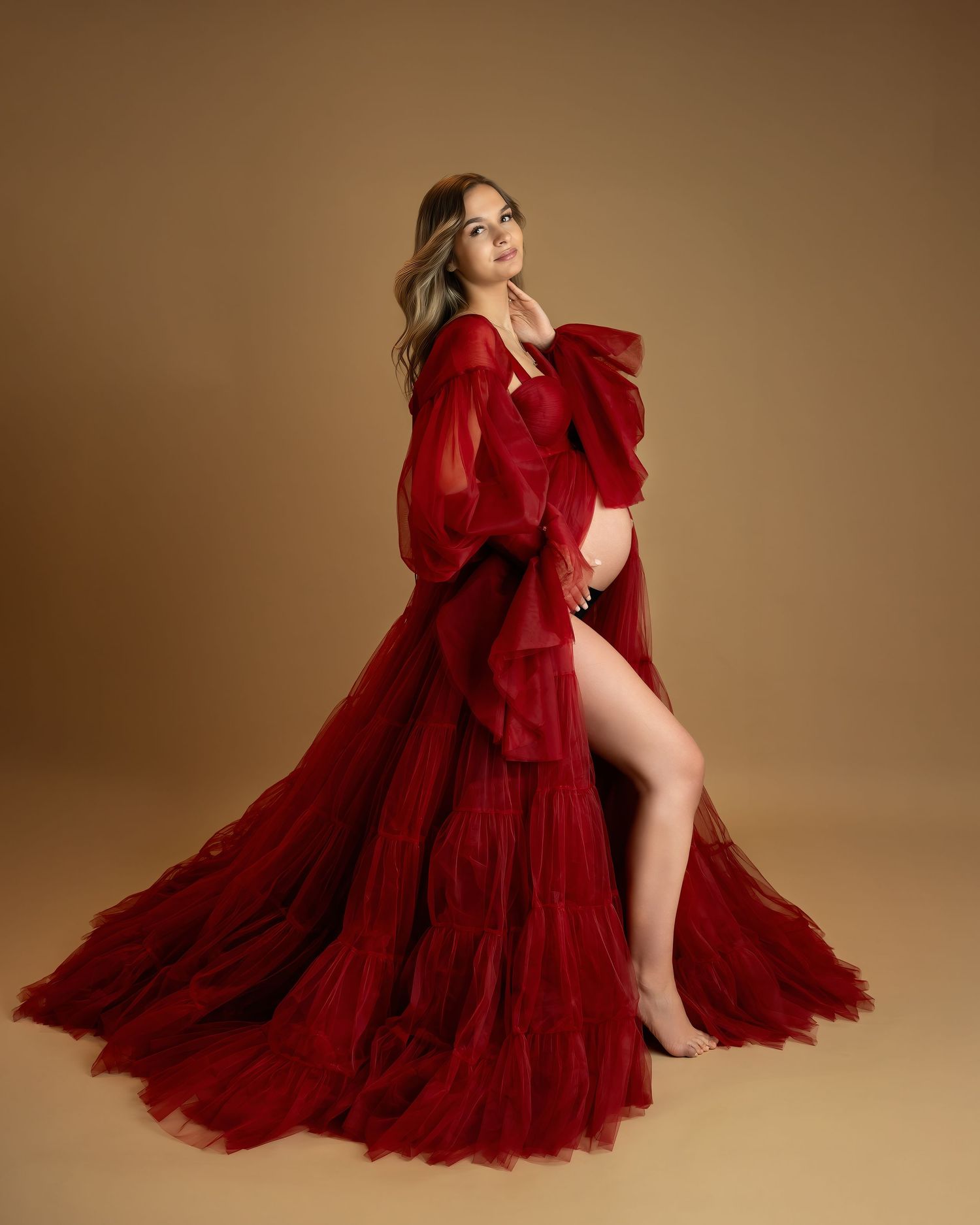 Maternity photoshoot in Gravesend Kent with pregnant woman in red dress posing in studio