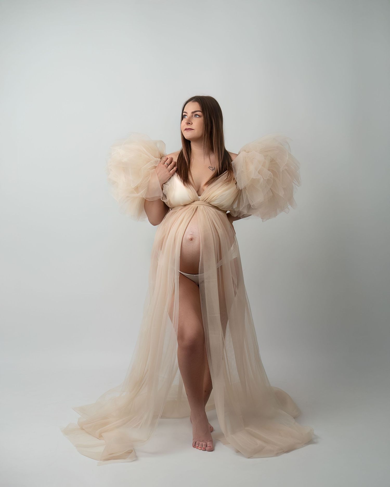 Maternity photography session in Gravesend Kent with pregnant woman in elegant beige gown in studio