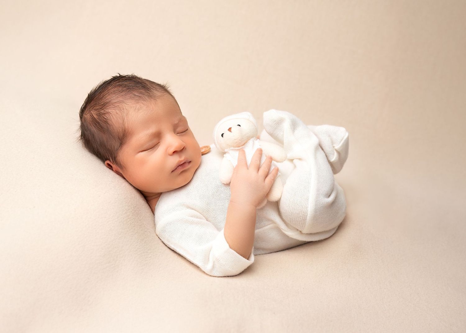 Newborn photography session in Gravesend Kent with baby lying on soft neutral background in studio