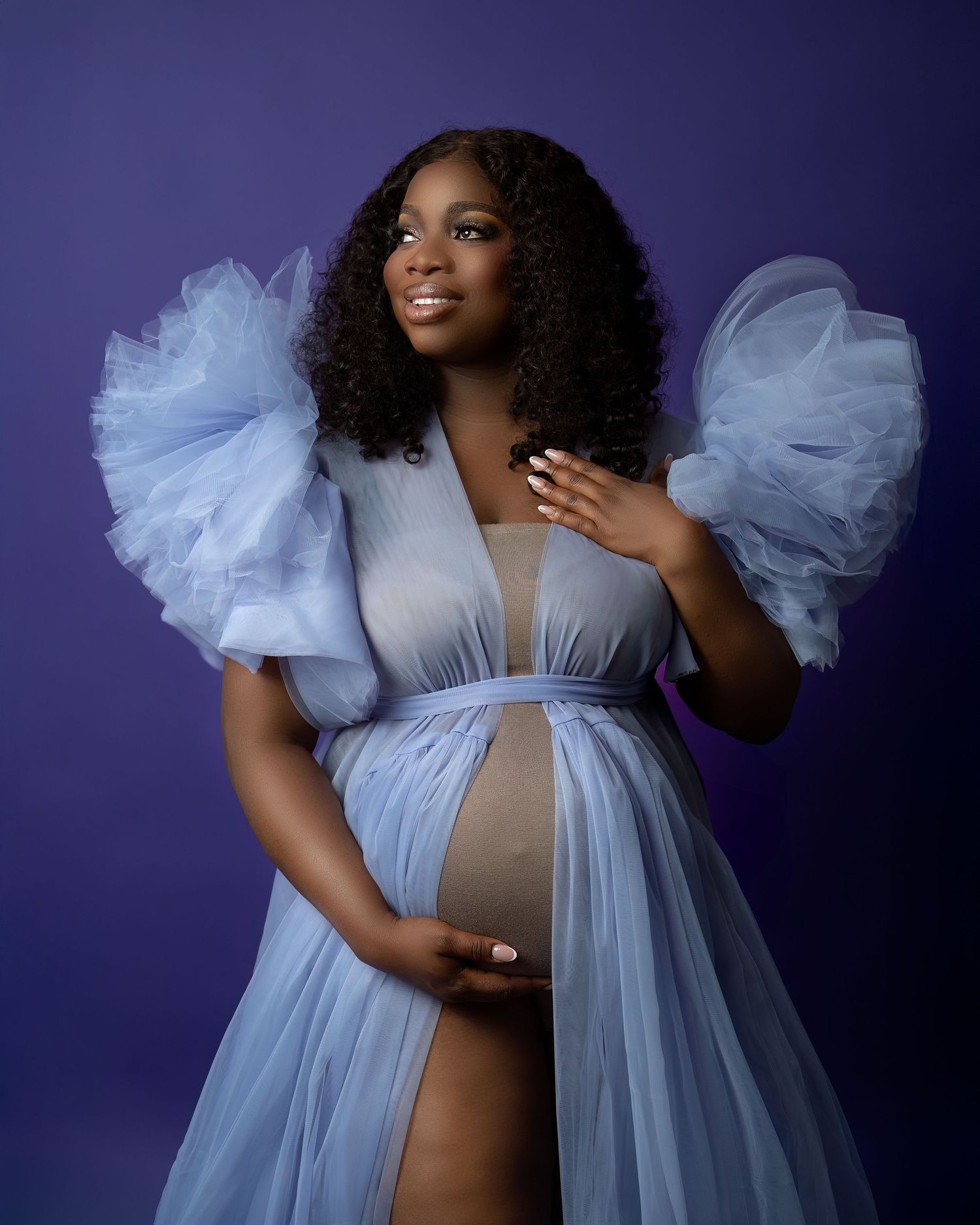 Maternity photography in Gravesend Kent with pregnant woman in blue dress posing in studio portrait