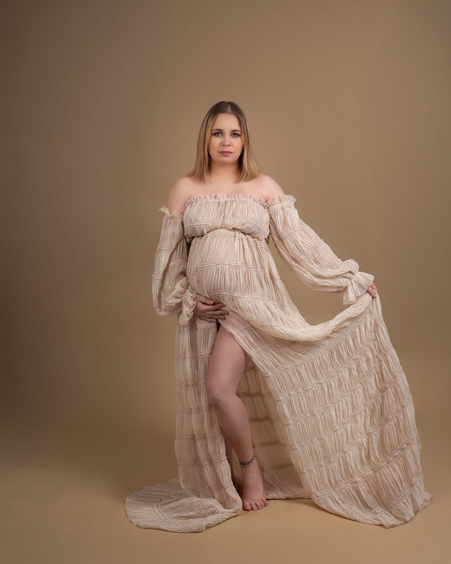 Maternity photography in Gravesend Kent with pregnant woman in soft beige flowing dress in studio