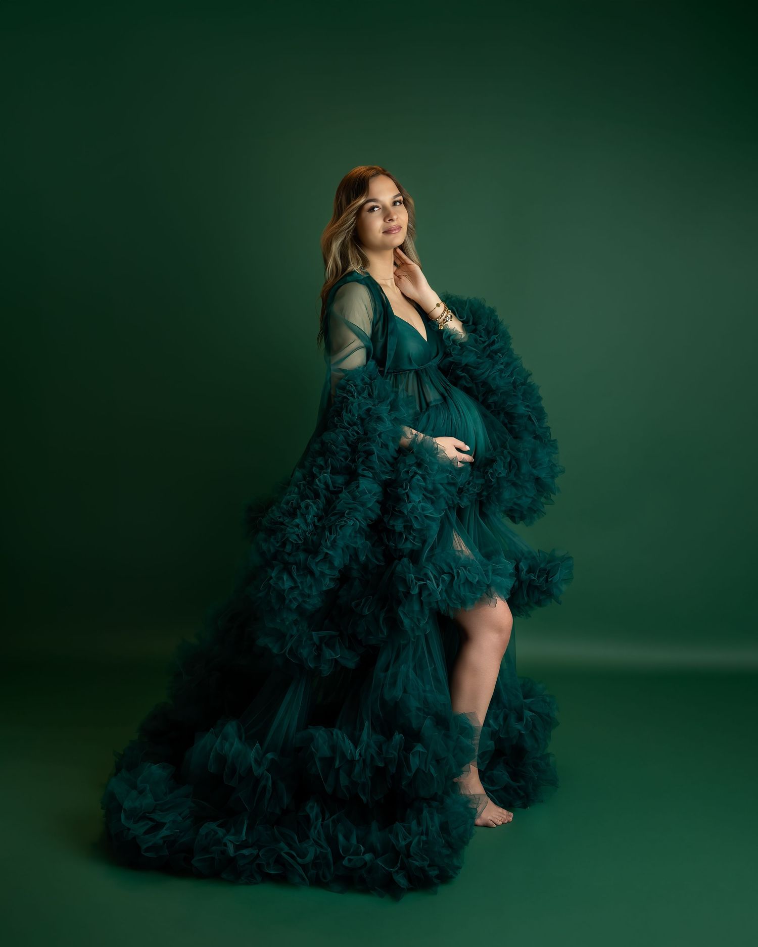 Maternity photography session in Gravesend Kent with pregnant woman in green gown on dark background