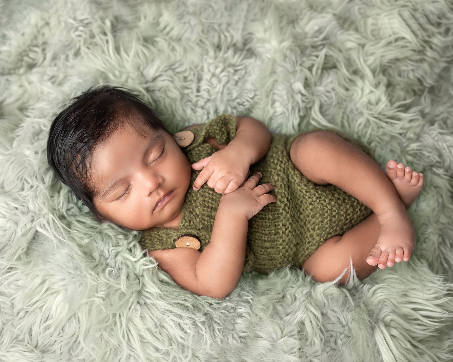 Newborn photography session in Gravesend Kent with baby lying on soft green blanket in studio
