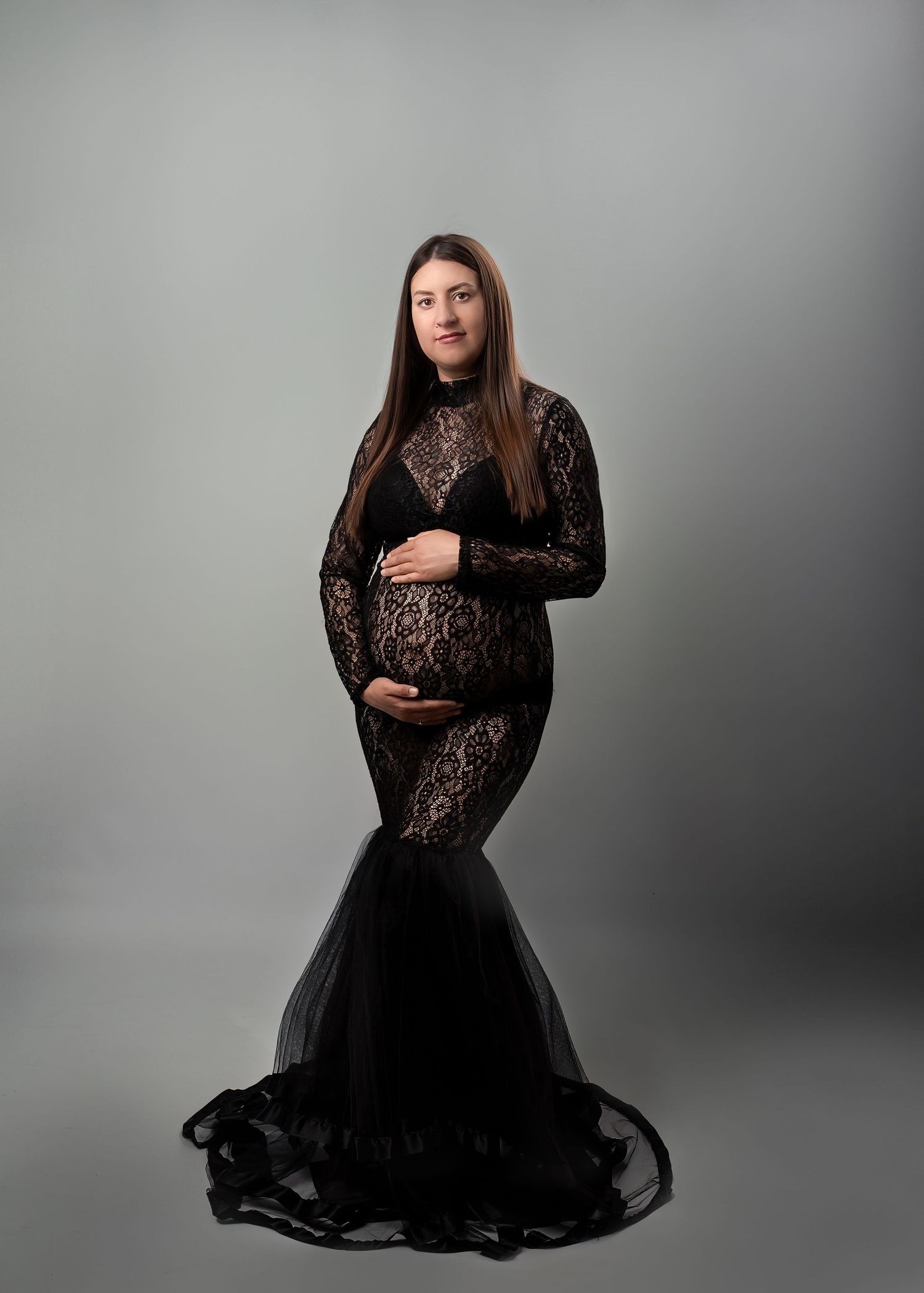Maternity photography session in Gravesend Kent with pregnant woman in black dress posing in studio
