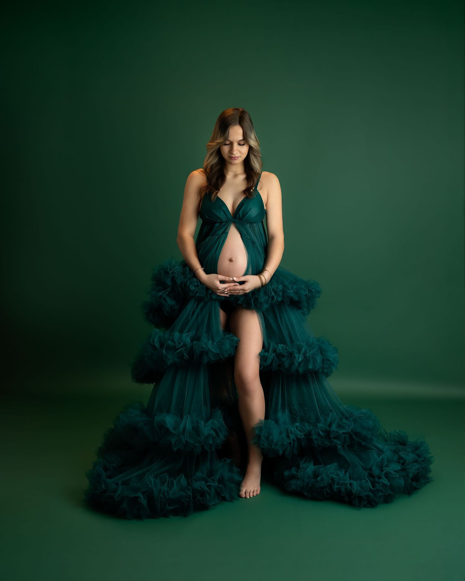 Maternity photography session in Gravesend Kent with pregnant woman in green gown sitting in studio