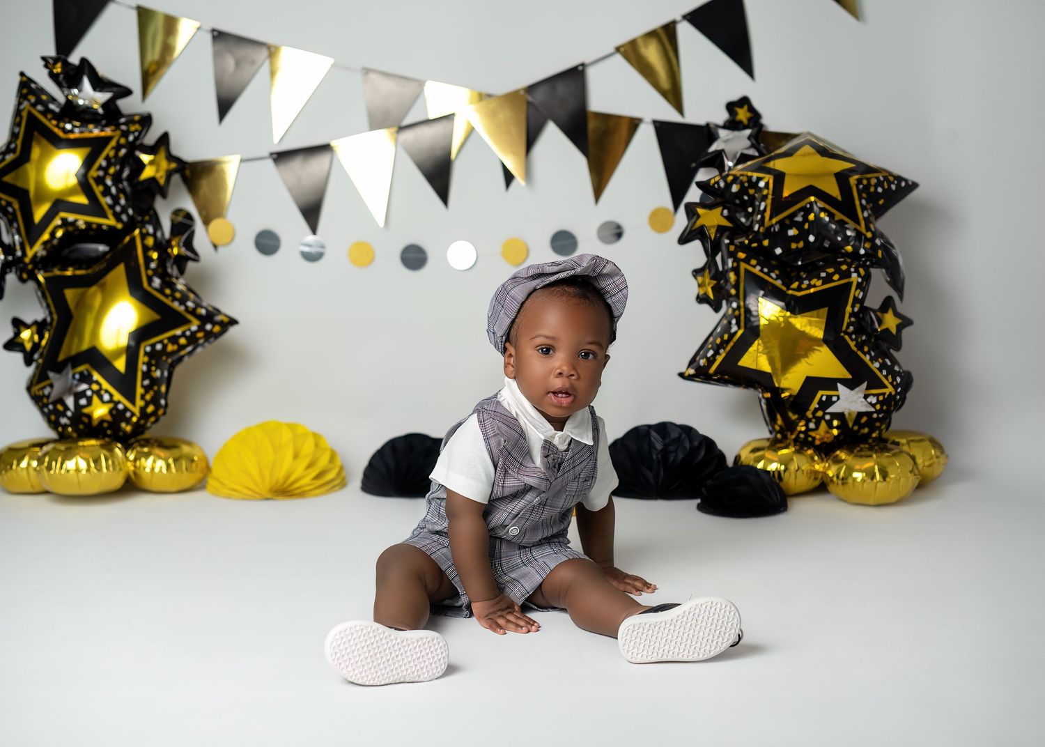 Cake smash photography in Gravesend Kent with black and gold birthday setup and balloons