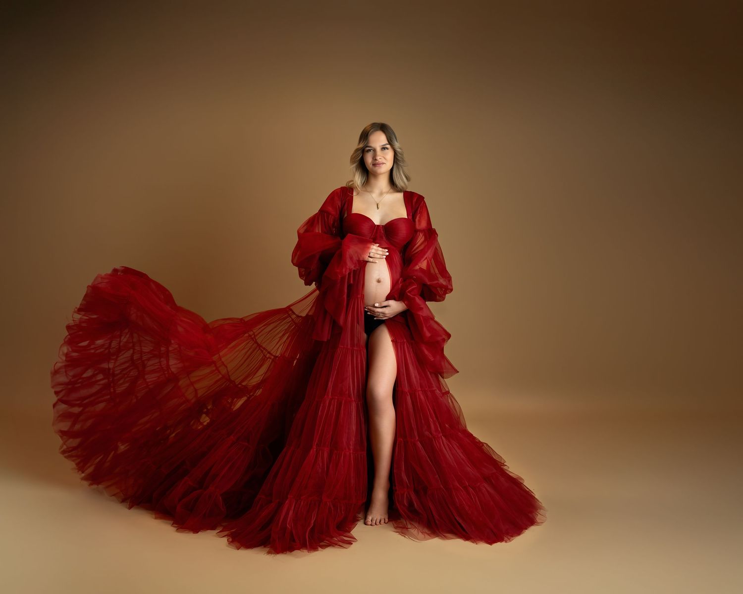 Maternity photography in Gravesend Kent with pregnant woman wearing elegant red gown in studio
