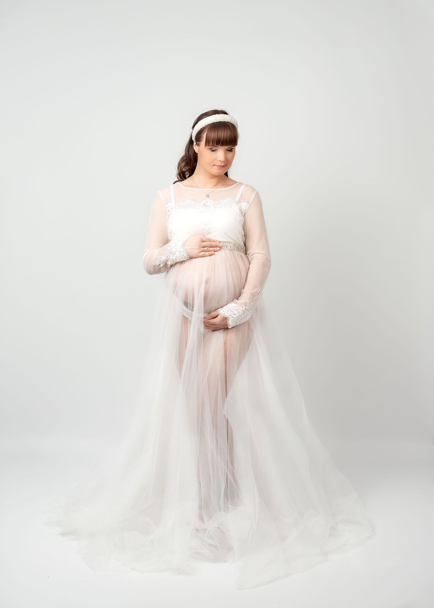 Maternity photography in Gravesend Kent with pregnant woman in white dress posing in studio