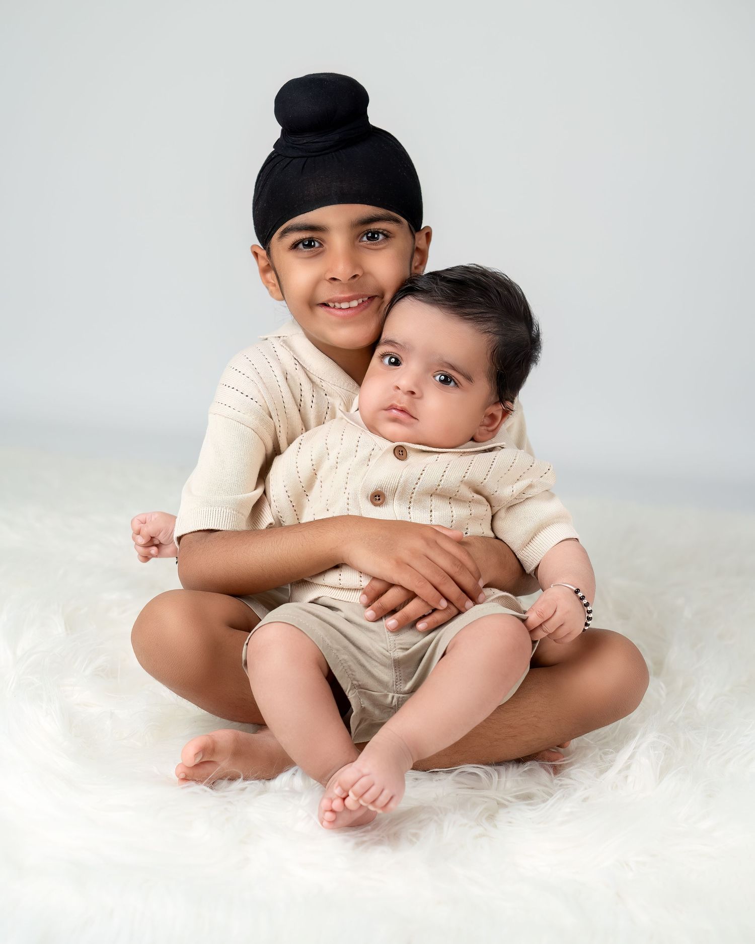 Family and newborn photography session in Gravesend Kent with sibling sitting and holding baby in studio